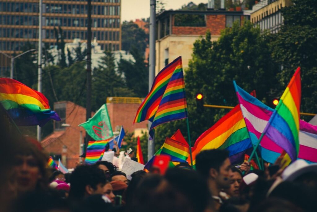 Rainbow flags displayed along Christopher Street near Stonewall Inn during NYC Pride week for global visitors