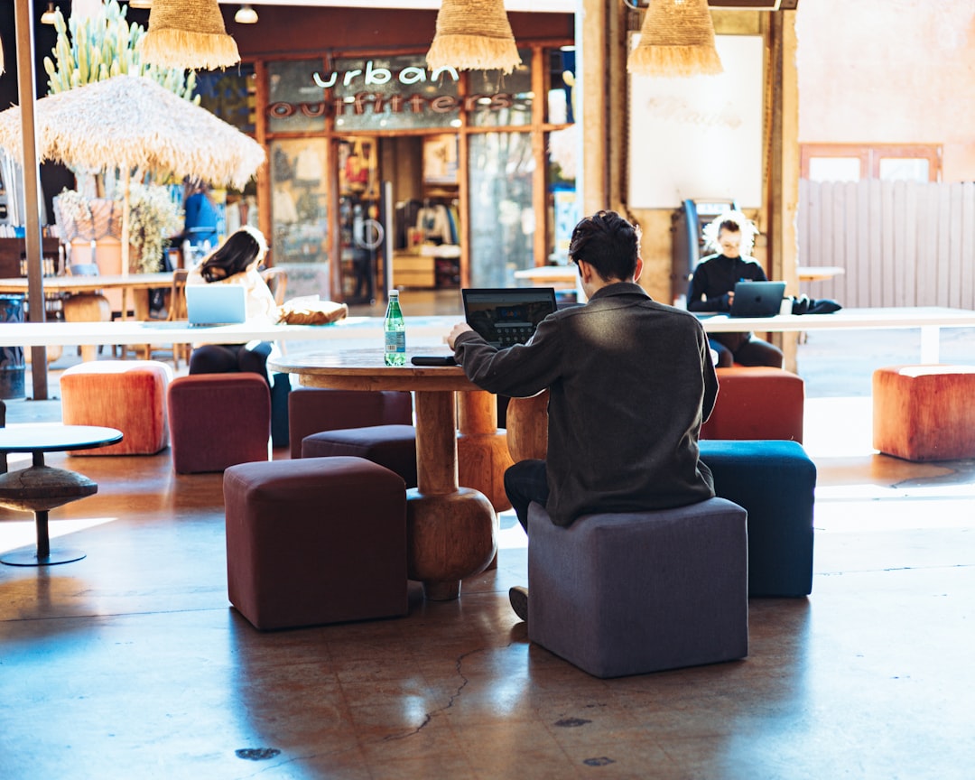 A man sits in a beautifully designed lounge, enjoying the calm atmosphere typical of private clubs in Manhattan.