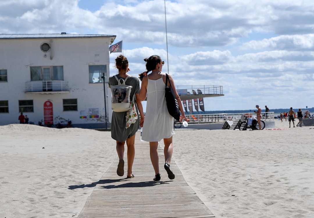 A couple walks the boardwalk on a summer day, enjoying the most popular day trip from NYC by train to the Jersey Shore