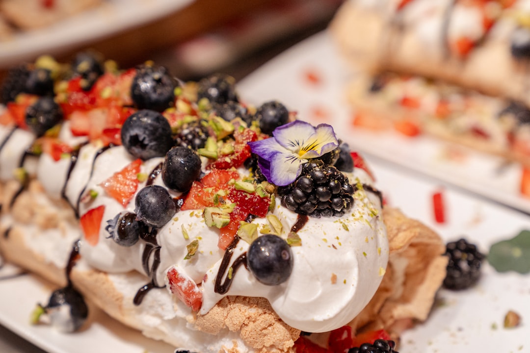 A couple shares a beautifully presented pavlova, one of the most celebrated late summer desserts on New York restaurants.