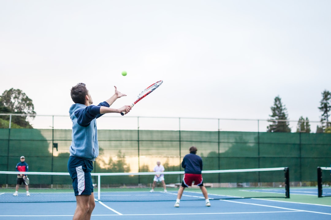 A tennis player serving on the hard courts at Flushing Meadows during a US Open match with the crowd behind them