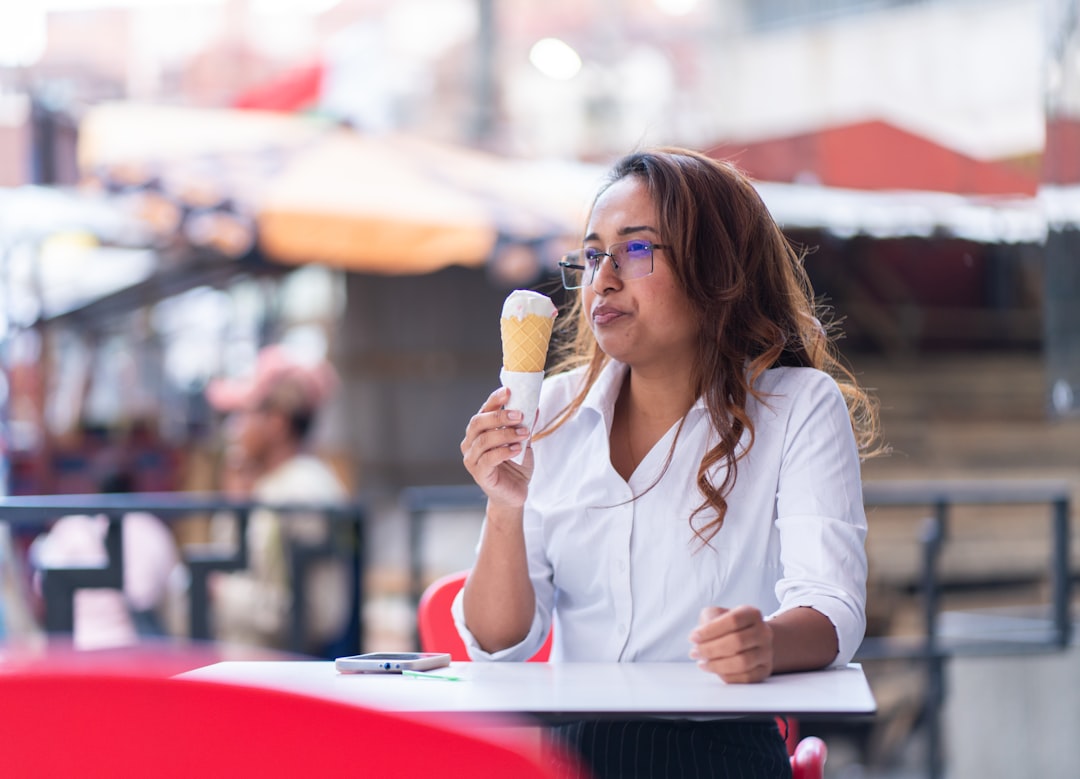 A woman enjoys artisan gelato on a New York City street, a perfect example of late summer desserts done the Italian way.