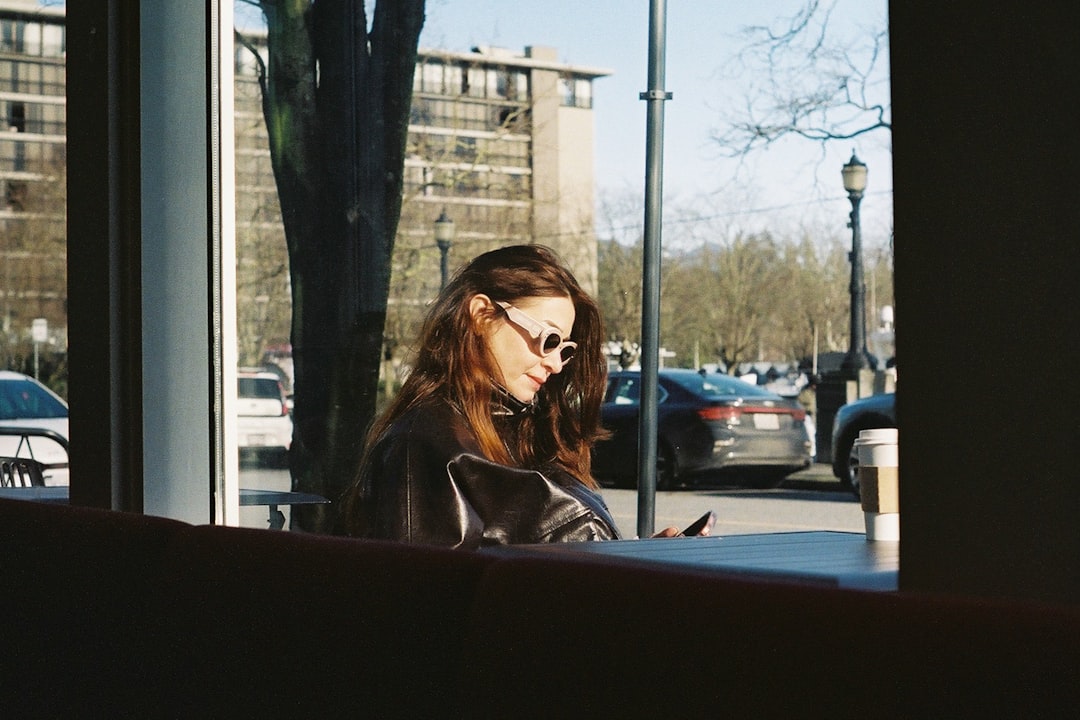 A woman rests near a warm café window as part of her autumn routine in New York City, closing a slow and intentional weekend.