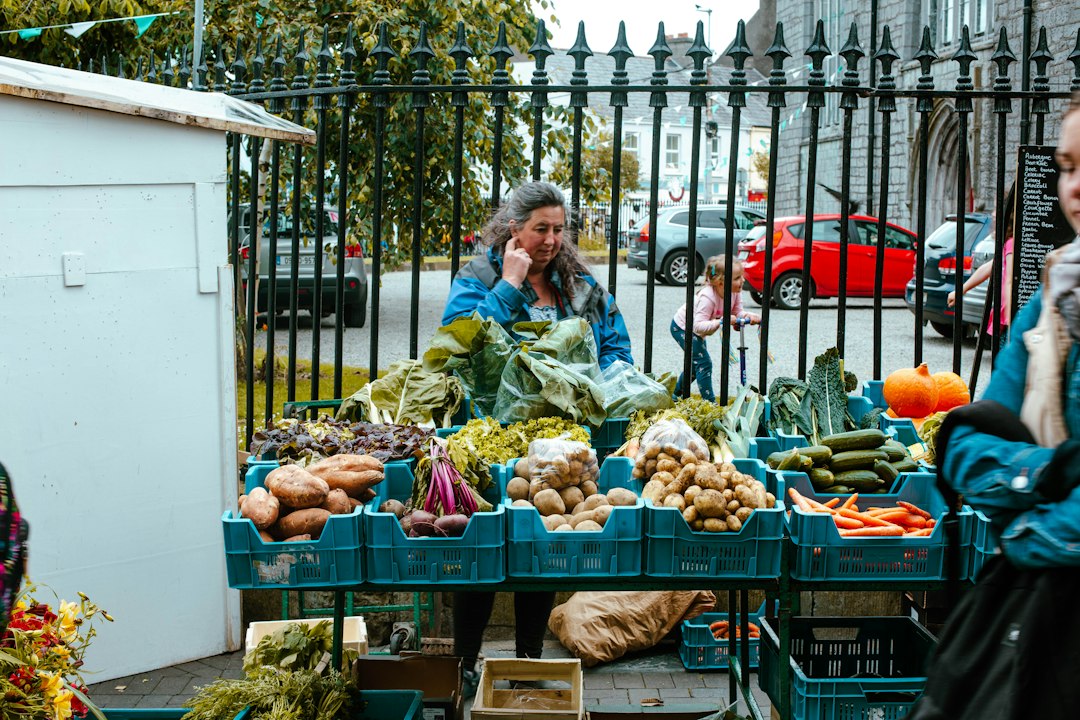 A shopper selects seasonal vegetables at a New York City farmers market, a key part of a mindful autumn routine.