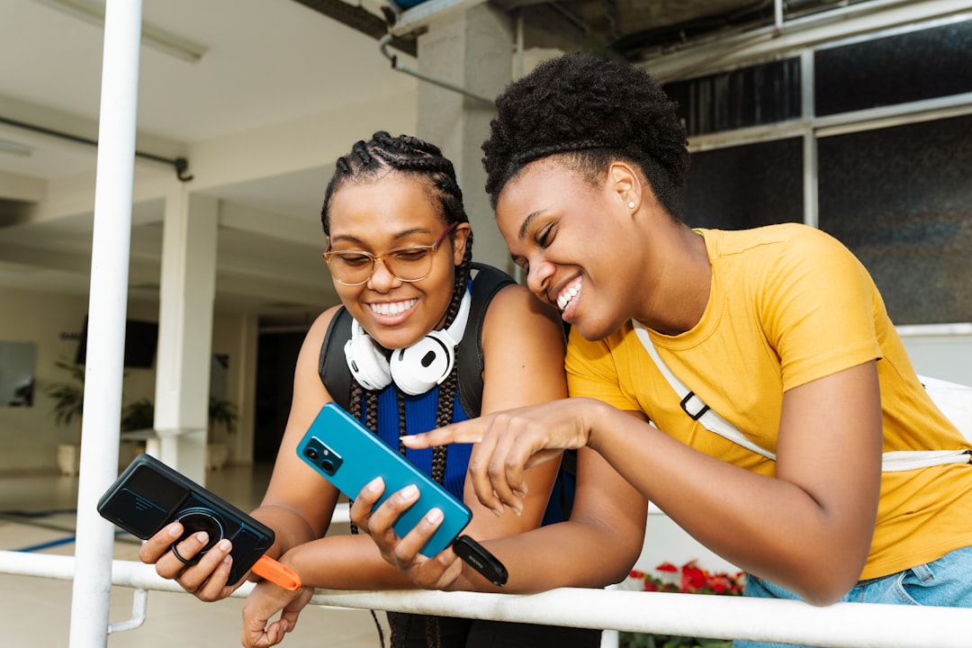 Two friends sharing a referral program invite on a smartphone