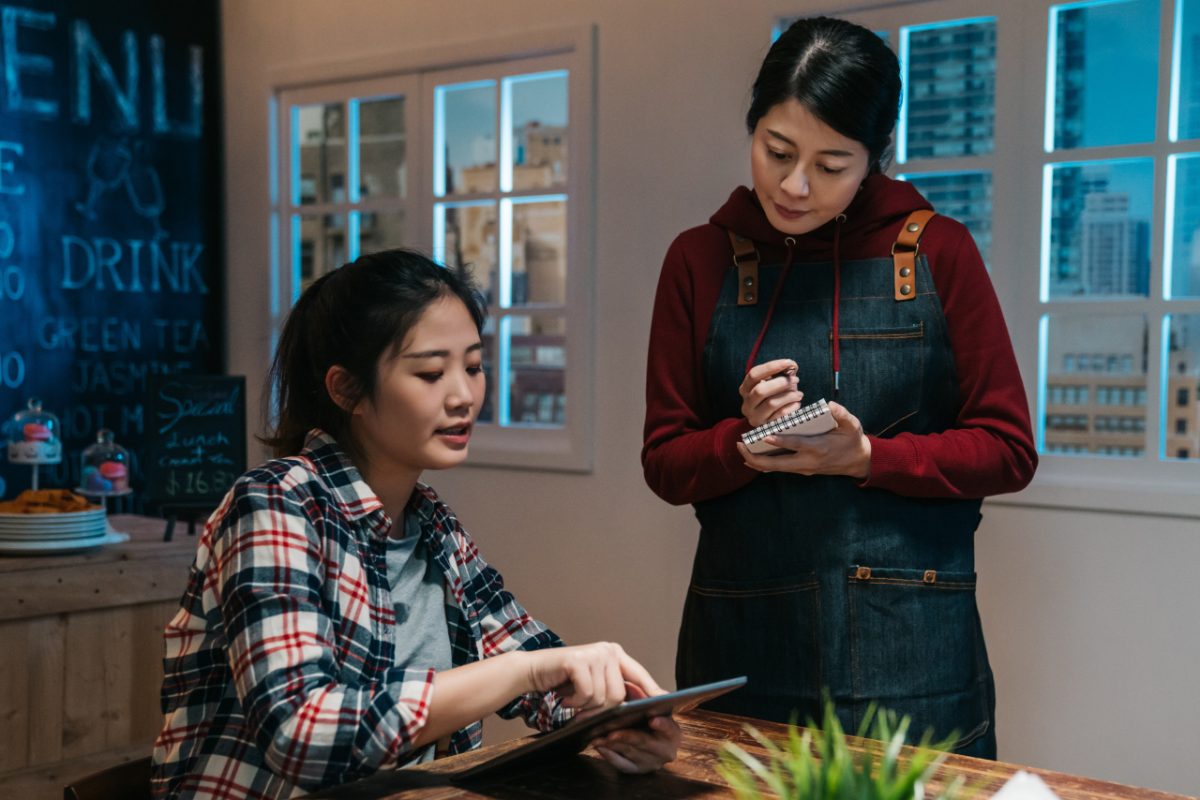 A server takes notes during service, building the personal knowledge that keeps loyal regulars coming back