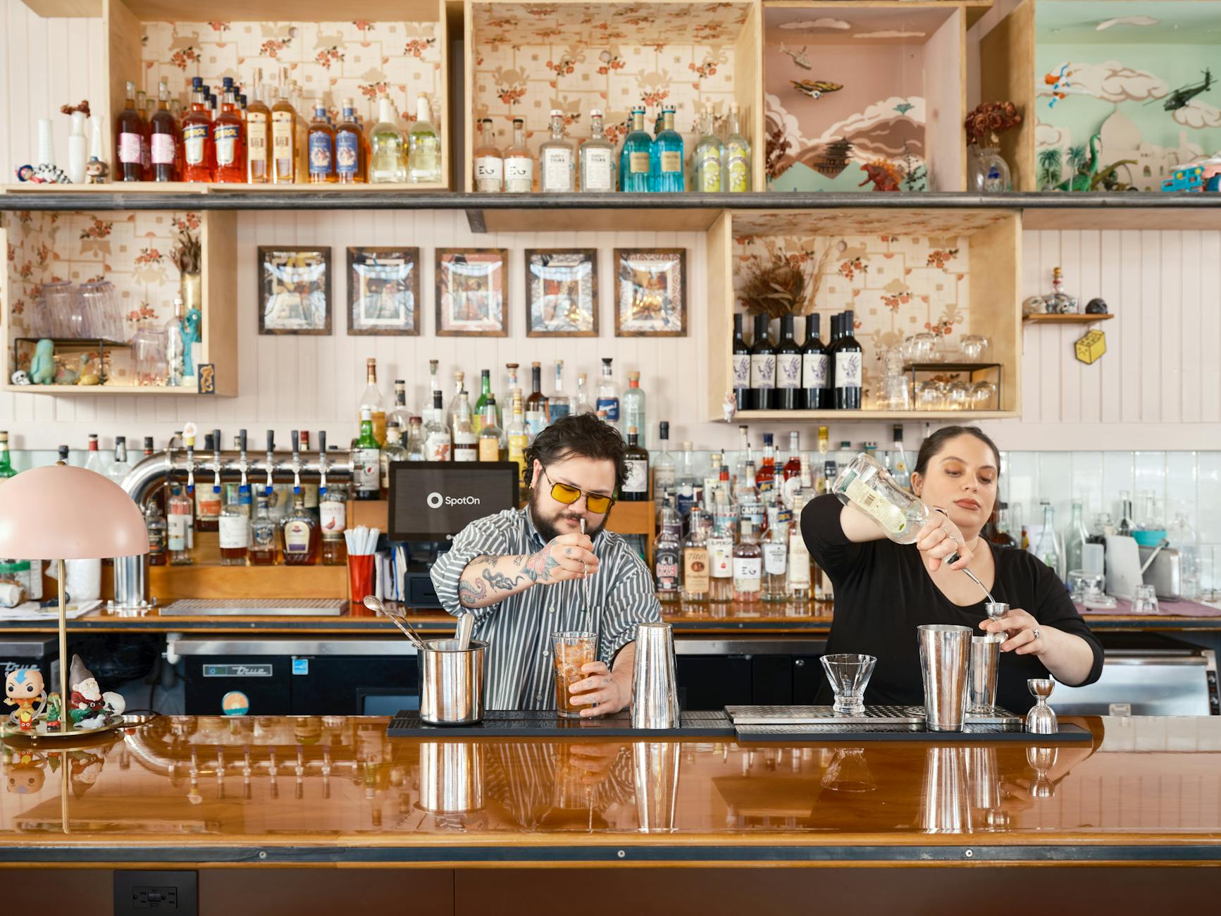 A beverage team engaged in mixology training, tasting and evaluating cocktails together before evening service