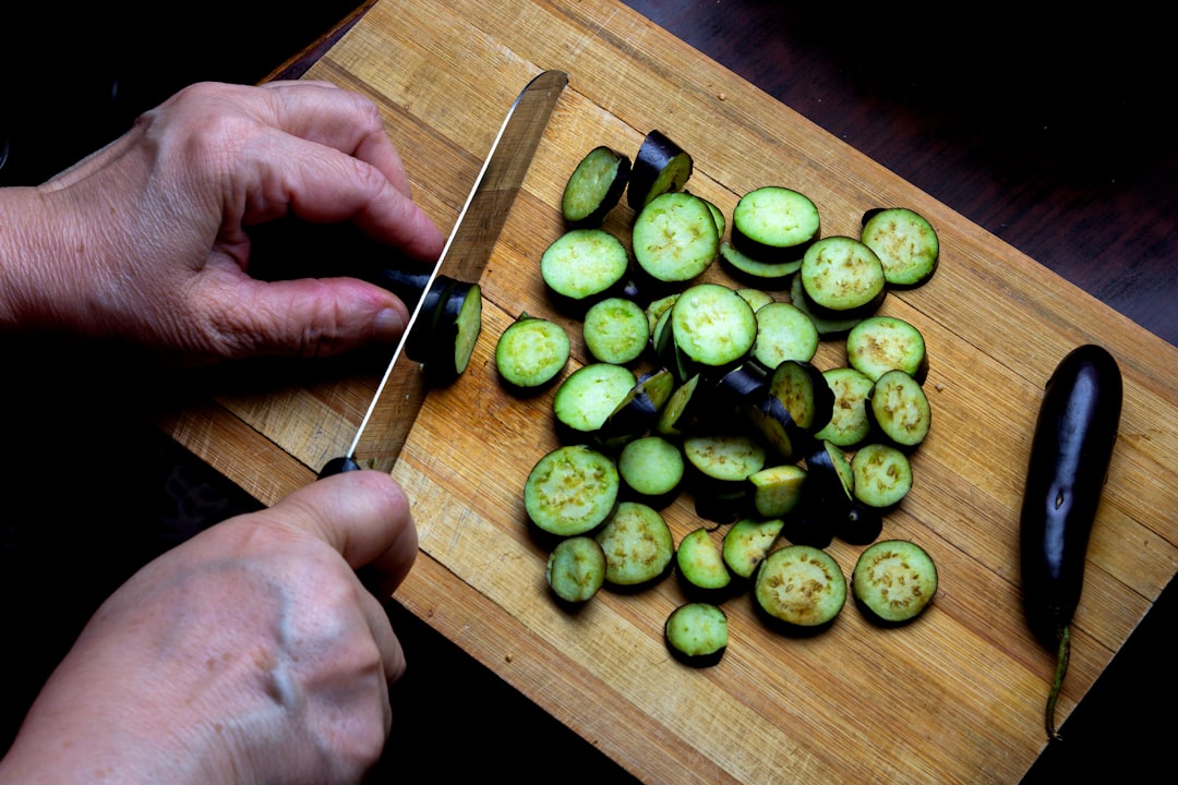 A home cook preparing sliced vegetables before placing them on the grill for smoky, charred flavor