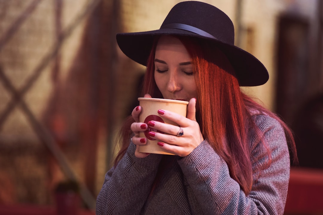 A woman lifting a cup of single-origin coffee to her nose and appreciating its distinct aroma at a coffee tasting