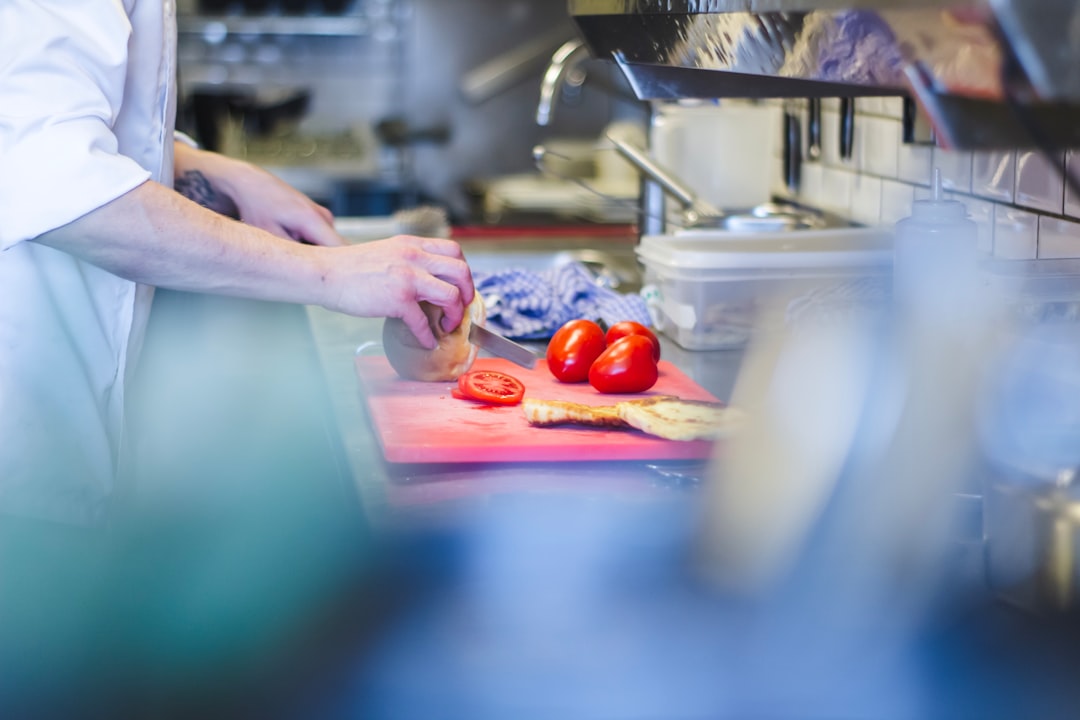 Uno chef ispeziona verdure fresche di stagione in cucina, verificando la qualità come parte di un rigoroso approvvigionamento fine dining