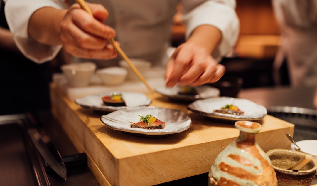 Uno chef giapponese che affetta con cura il pesce fresco, un momento decisivo nella cultura culinaria costiera
