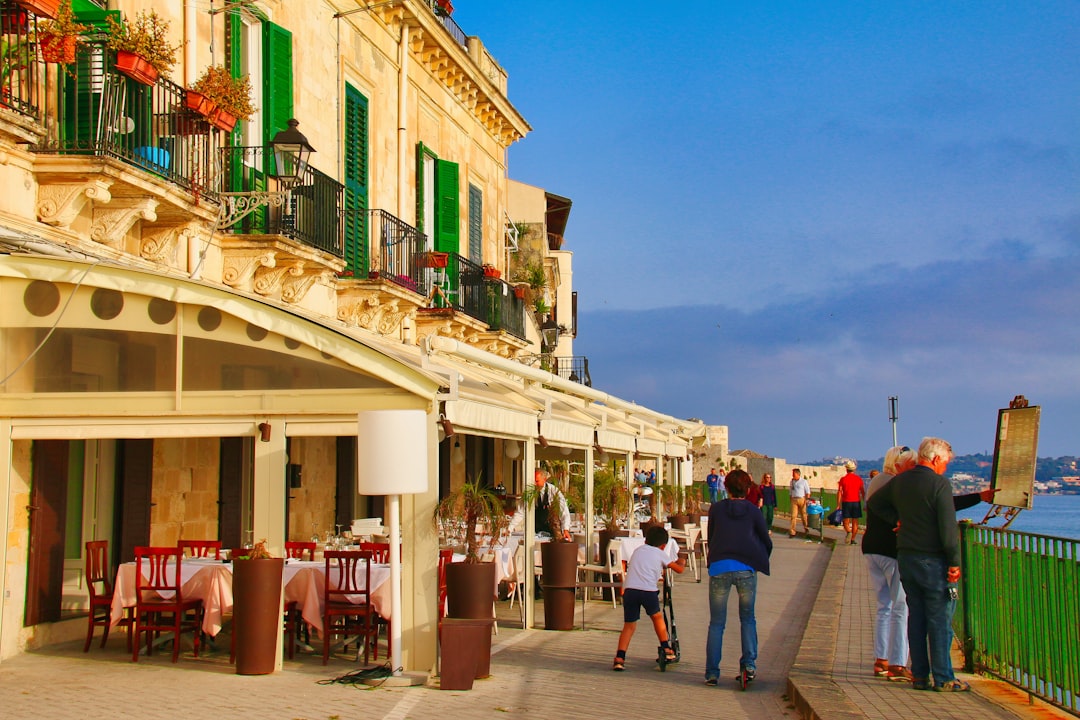 Una famiglia che condivide un pasto leggero a base di pesce su una terrazza costiera, celebrando le tradizioni estive della cucina costiera