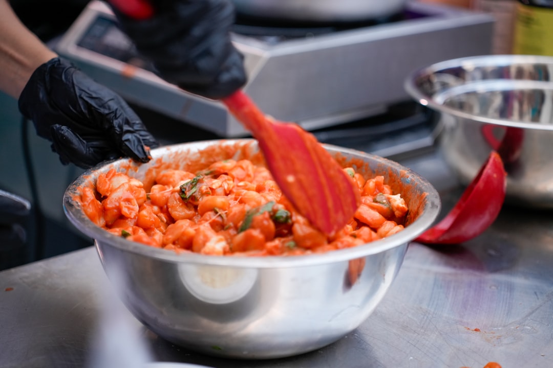 Una donna prepara piatti classici di pomodoro sul fornello in una luminosa cucina mediterranea