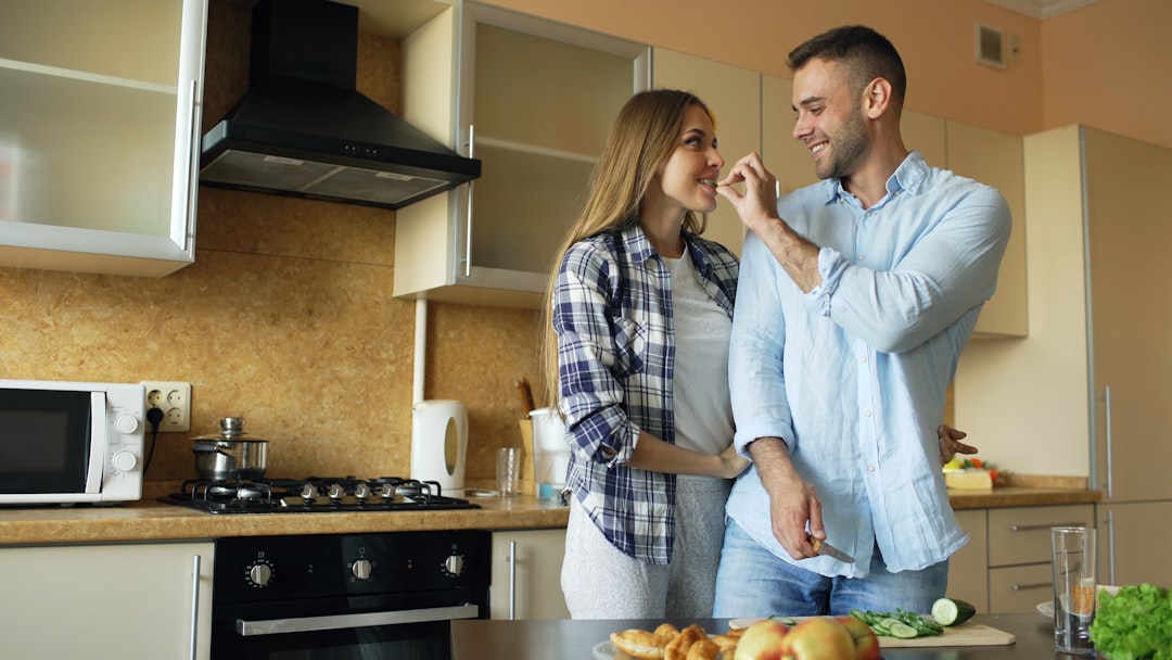 Un cuoco sorridente che assaggia un piatto sul fornello dopo aver scelto di adattare istruzioni di ricetta