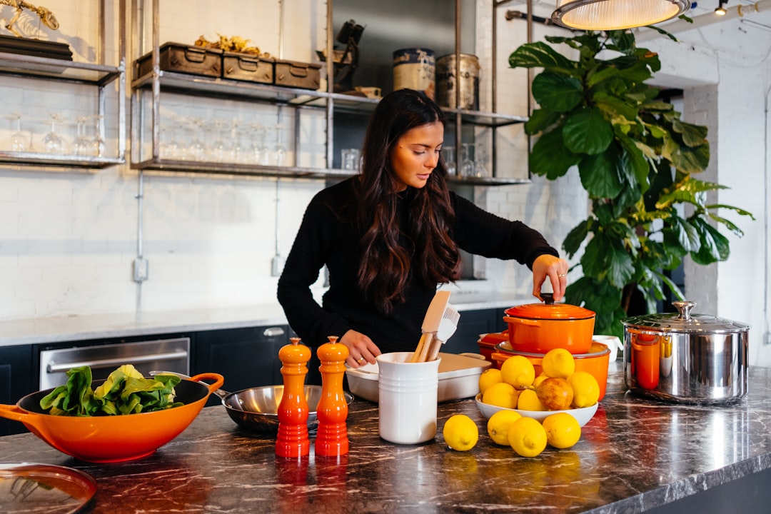A home cook slicing ripe peaches on a wooden board, preparing ingredients for a classic stone fruit dessert.