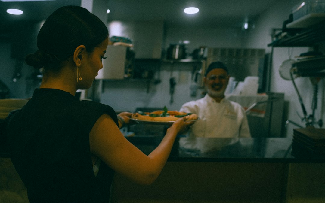 A chef and front-of-house staff member review ingredient details together before hotel dining service begins