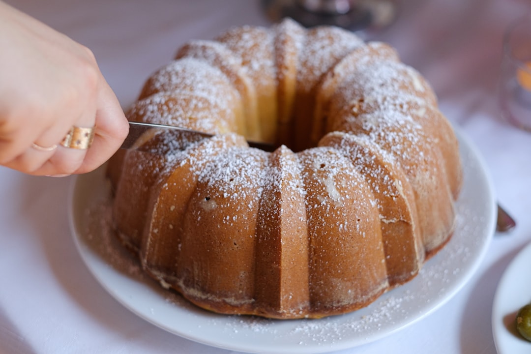 A person slices a spiced pear and walnut cake as part of a series of autumn dishes celebrating harvest-season baking