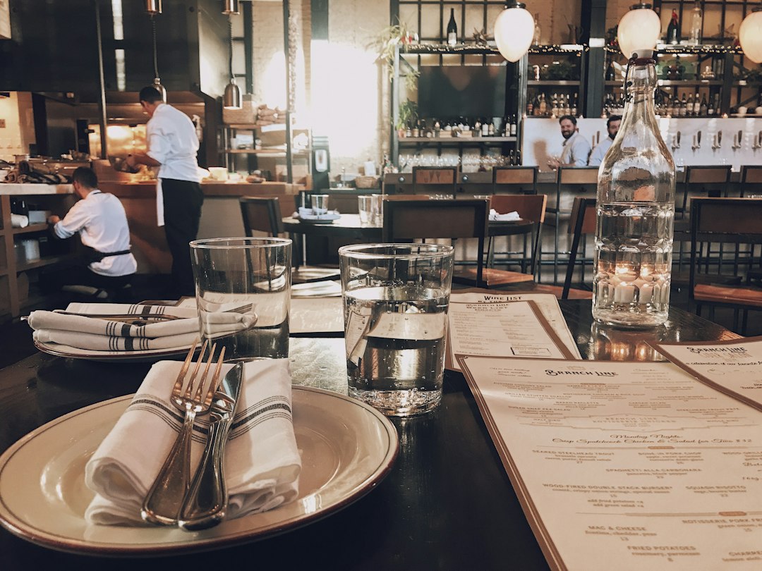 Diner comparing dishes shaped by careful menu pricing at a bistro table