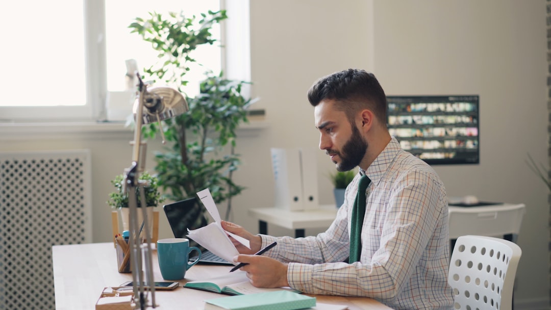 Un professionista prepara documenti di associazione per affittare una postazione in un co-working a Shibuya senza un garante giapponese.
