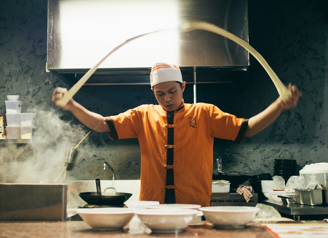 Uno chef in una cucina di Tokyo che prepara con cura ramen senza glutine in una cucina dedicata senza grano.