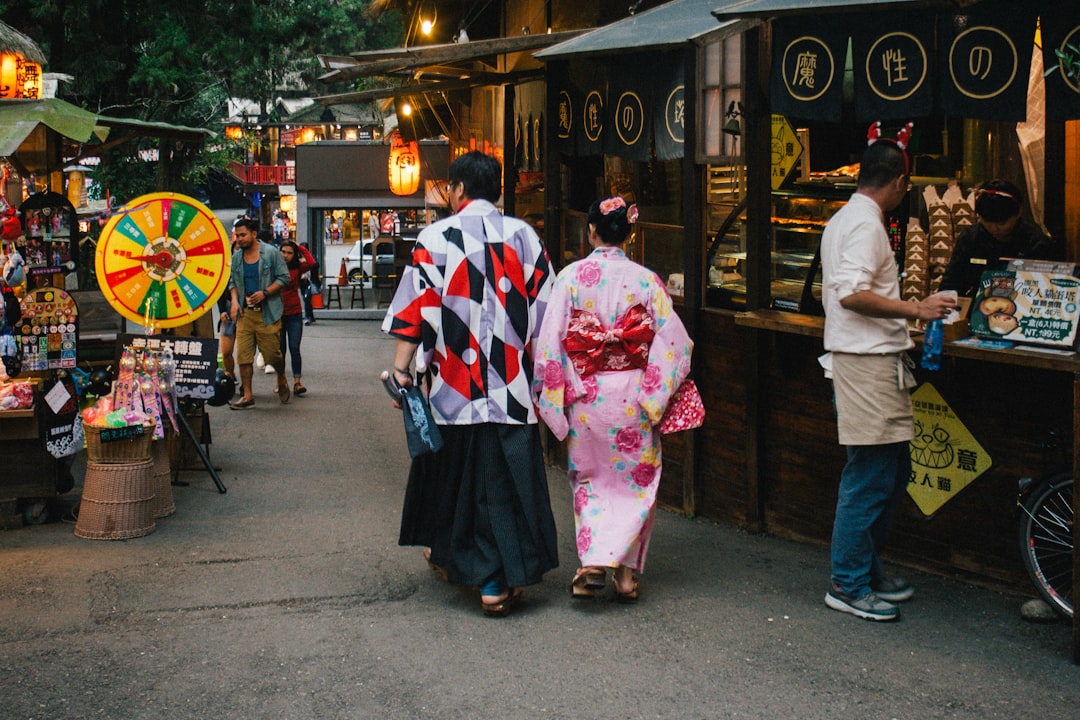 Una coppia passeggia davanti alle bancarelle di cibo a un festival estivo giapponese vicino all'area di osservazione delle lucciole di Fussa nella parte occidentale di Tokyo