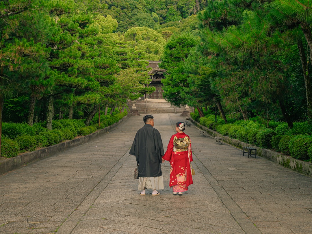 Un couple parcourt un chemin de temple brumeux entouré d'hortensias de Tokyo en pleine floraison pendant la saison des pluies.