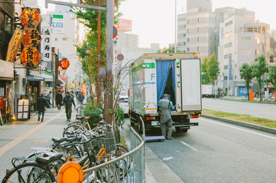 Un conductor de entrega descargando cajas con temperatura controlada como parte de la cadena de suministro de la cultura konbini en Tokio