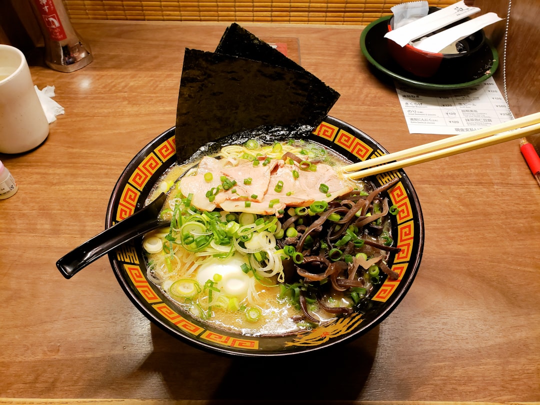 Un gruppo di amici che condivide tagliatelle udon senza glutine in un piccolo ristorante di Tokyo, celebrando una cena sicura e deliziosa.