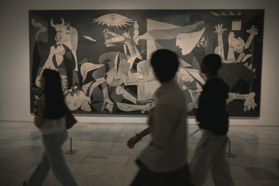 Un hombre mirando de cerca una obra de arte de la exposición de Picasso rodeado de vibrantes detalles de diseño en Roppongi, Tokio