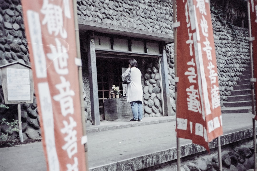 Un ospite passa attraverso la tenda noren di un onsen di quartiere a Tokyo, trasportando un piccolo asciugamano e un cesto di oggetti personali.