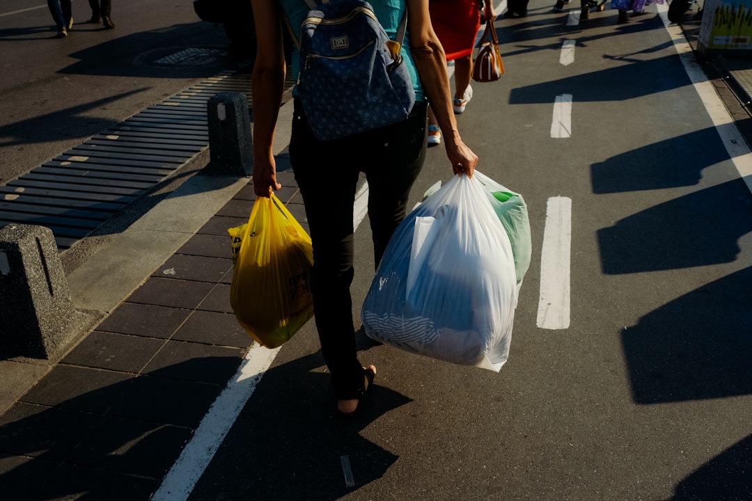 Un residente en Tokio sosteniendo bolsas transparentes listas para la clasificación de basura en el día de recolección fuera de un edificio de apartamentos