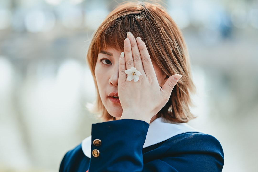 Una mujer mostrando su arte de uñas de Tokio completado, con un delicado motivo de temporada en gel suave