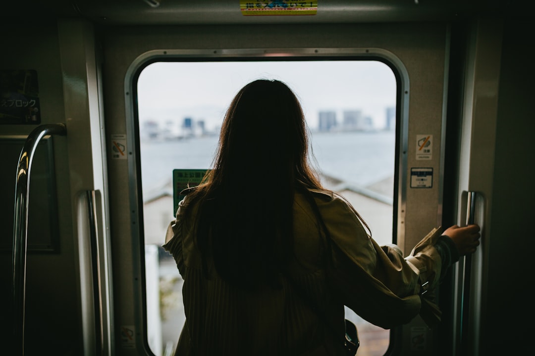 Una donna guarda attraverso il finestrino di un treno mentre è in viaggio per una serata di osservazione delle lucciole a Fussa, nella zona ovest di Tokyo.