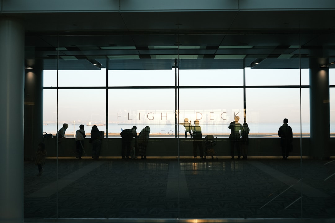 Viajeros de negocios caminan por una terminal de aeropuerto de Tokio, reflejando el papel de la ciudad como una sede líder de Tokio