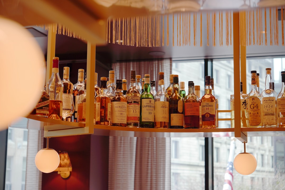 Un sommelier sélectionne une bouteille de whisky japonais rare pour une dégustation dans un bar d'hôtel de Tokyo