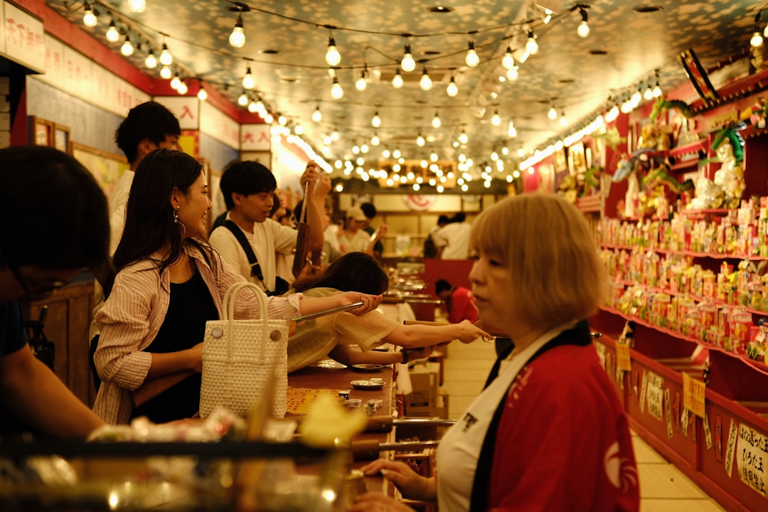 Un acquirente senza glutine che esplora i banconi di cibo pronto di un mercato depachika di Tokyo all'ora di chiusura