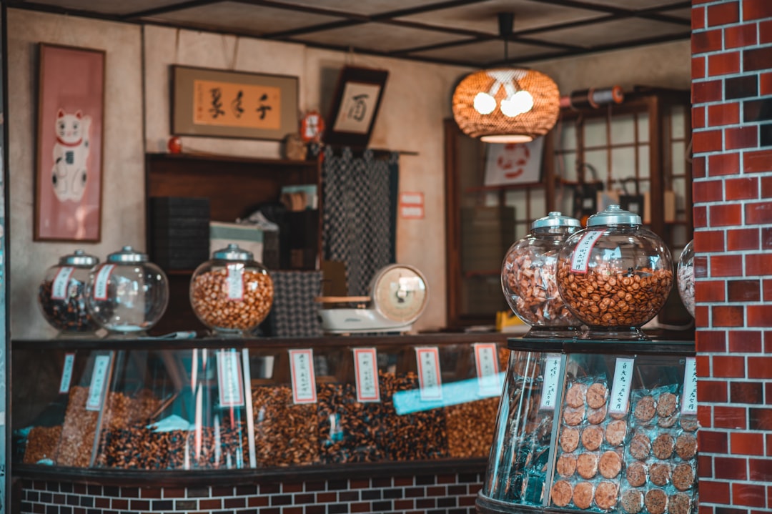 Una persona scansiona le etichette degli alimenti giapponesi al banco di un minimarket di Tokyo, controllando i kanji per il glutine.