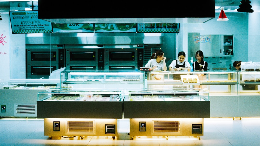 Una donna sceglie una pagnotta di pane al latte presso il banco di una panetteria giapponese a Tokyo, circondata da prodotti appena sfornati.