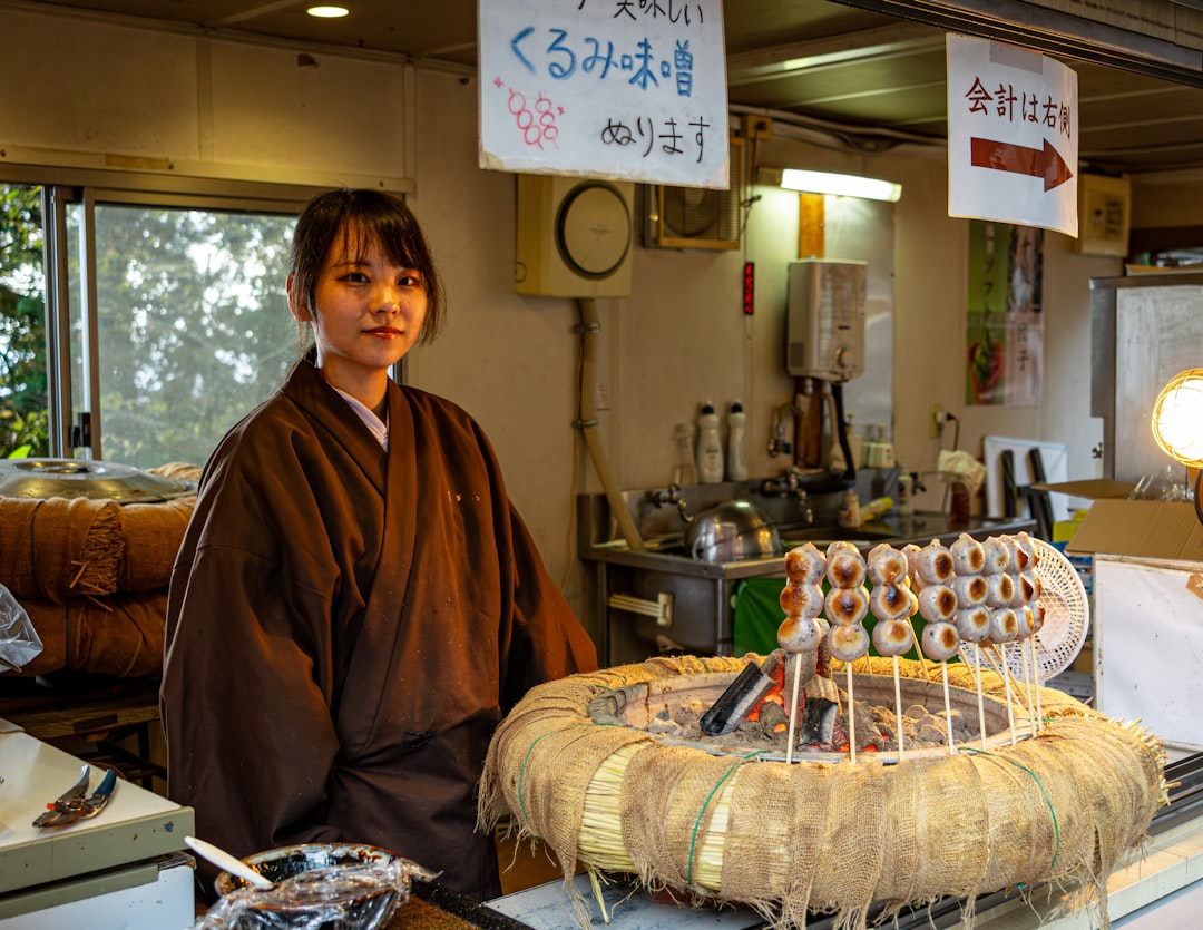 Una donna che esamina mochi wagashi splendidamente confezionati al banco di un depachika di Tokyo.