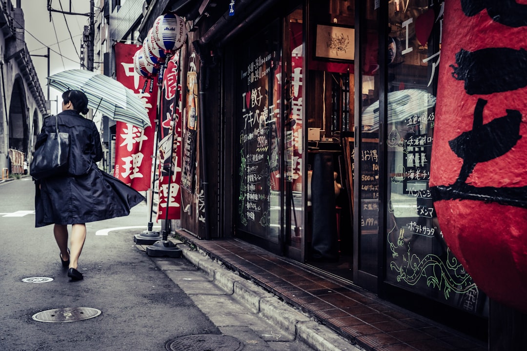 Una donna professionista indossa un completo in lino traspirante mentre cammina per una strada di Tokyo.