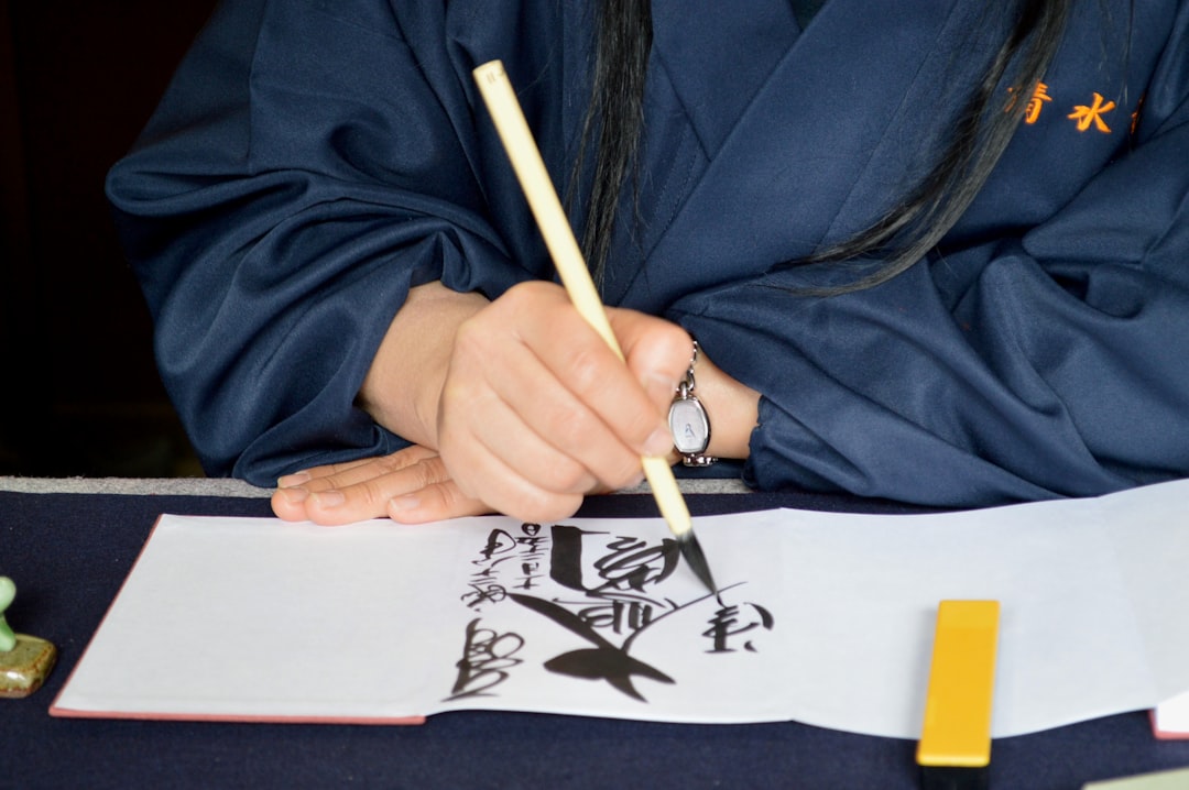 Uma menina pratica caligrafia com um pincel em uma oficina de artesanato em Tóquio, durante a semana de férias escolares de Obon.