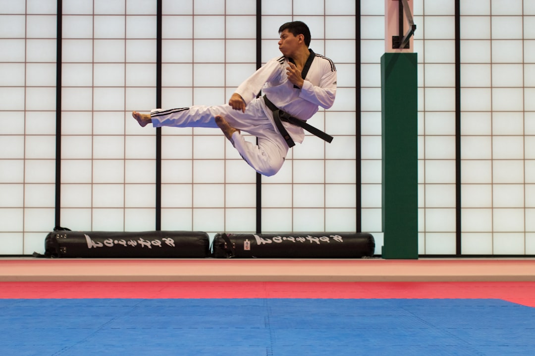2 Estudiantes adultos practican una técnica de lanzamiento de judo en la colchoneta en un dojo de Tokio bajo supervisión en inglés