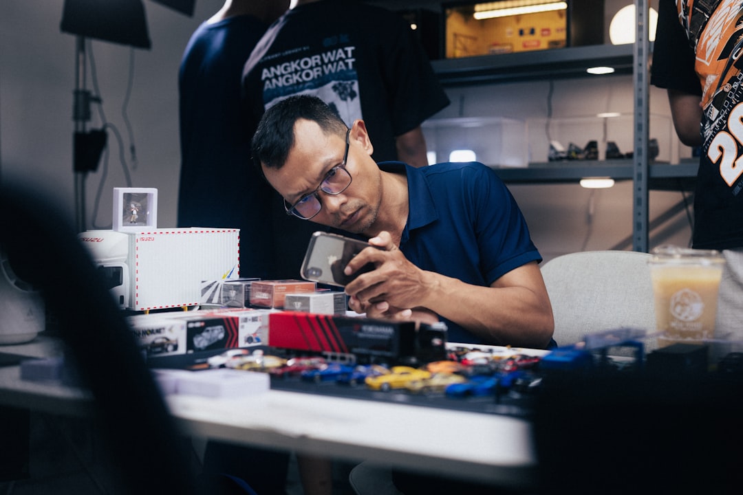 Un volontario esperto ripara un piccolo dispositivo elettronico in un repair café di Tokyo, dimostrando la sostenibilità pratica.
