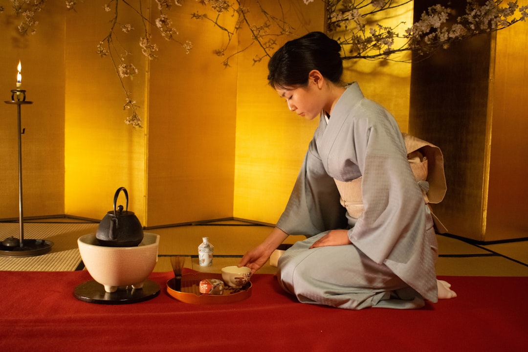 Un huésped se relaja con té de cebada frío sobre una alfombra de tatami dentro de un ryokan de Kagurazaka durante el intenso calor del verano de agosto.