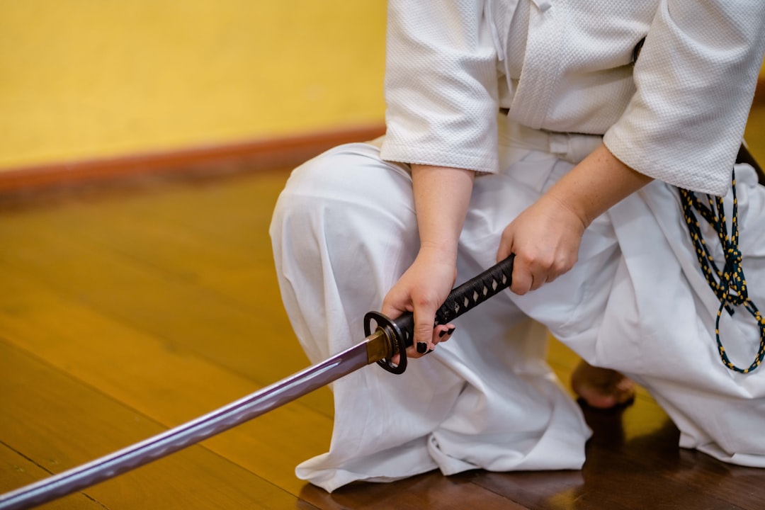Una mujer con armadura completa de kendo practica técnica de espada en un dojo de Tokio que enseña en inglés