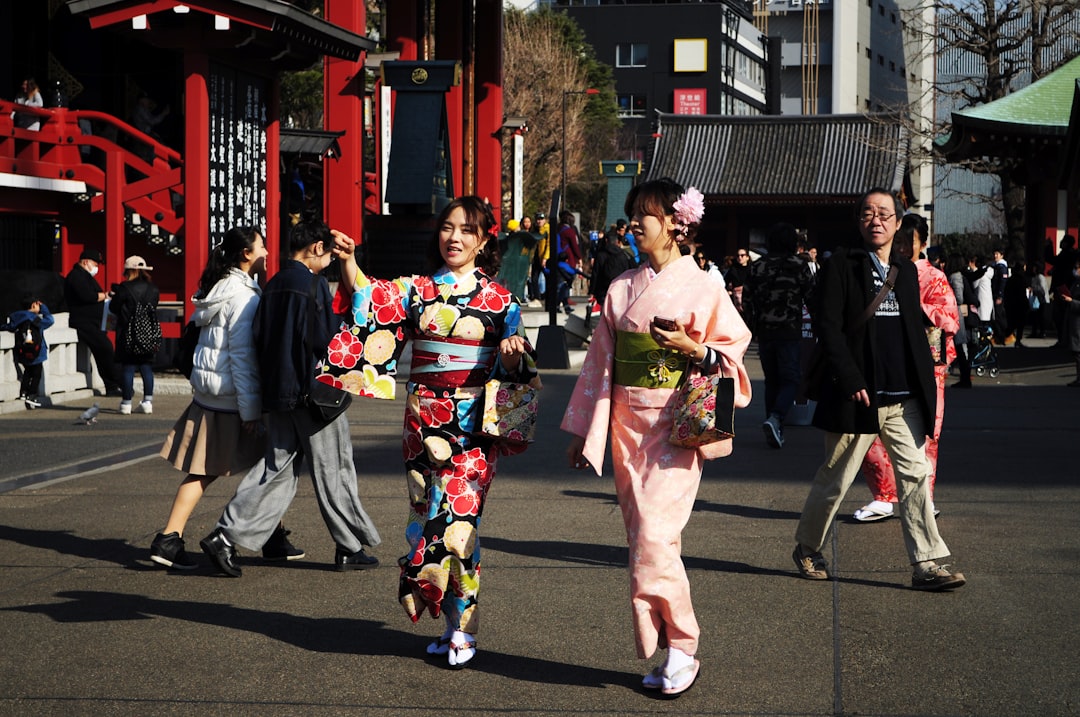 Deux amies parcourent des vêtements colorés sur un marché vintage de Tokyo, découvrant la mode yukata de seconde main avec soin et joie.