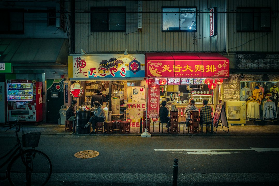 Un touriste achète de la nourriture de rue auprès d'un vendeur dans une rue d'investissement shotengai de Tokyo, et le double local et tourisme.
