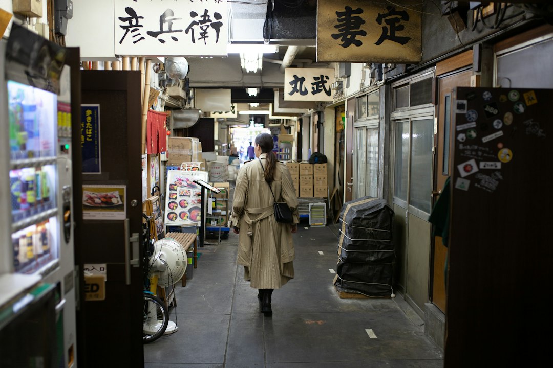 Une femme parcourt les marchandises sur un stand dans une rue d'investissement shotengai dans un quartier résidentiel de Tokyo.