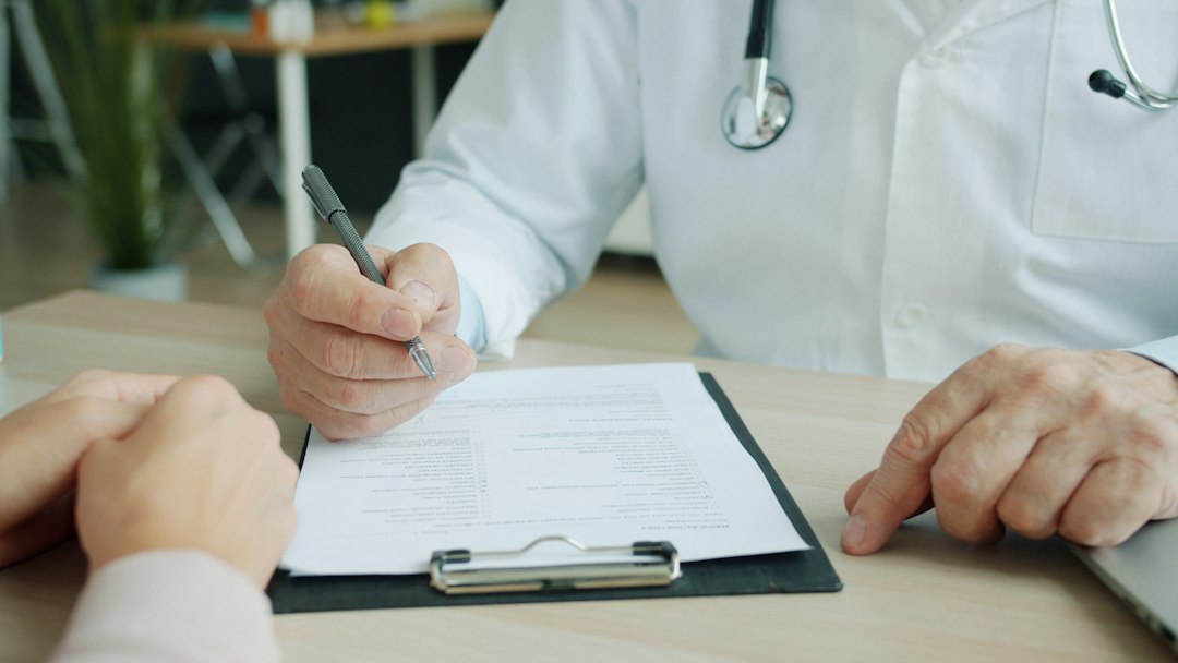Dermatologo che esamina la pelle secca di un paziente in una clinica di Tokyo