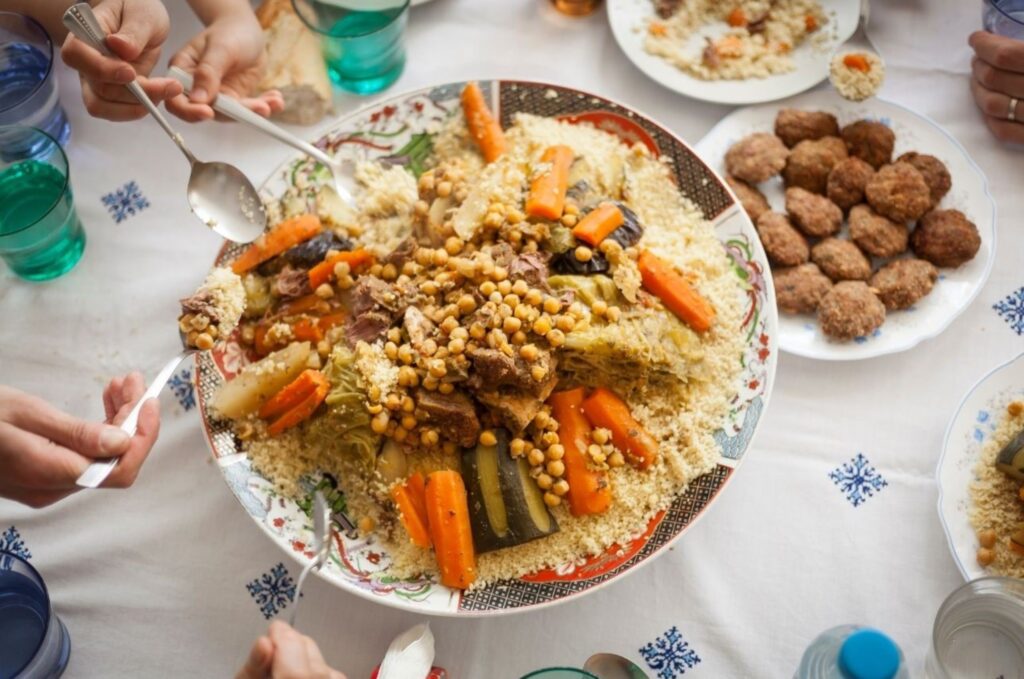 Famille berbère amazighe célébrant Yennayer, le Nouvel An, avec un festin traditionnel dans un village des montagnes de l'Atlas, durant la saison des fêtes multiculturelles du Maroc, mettant en valeur d'anciennes traditions agricoles et un riche patrimoine culturel